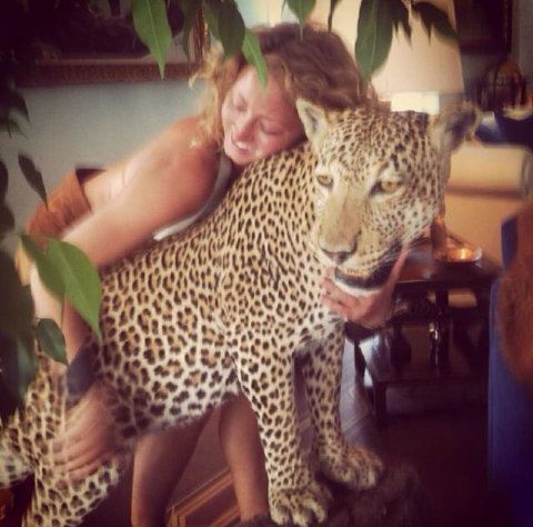 This poor jungle cat, all doped up, being fondled/groped/who-knows by a young woman who is indeed modeling and selling bizarre leather outfits that, all jokes aside, could've been worn by Charlize Theron(sp?) in Fury Road. This poor jungle cat's sitting there thinking, "My life sucks."